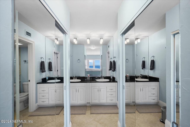 bathroom featuring vanity, tile patterned floors, and toilet