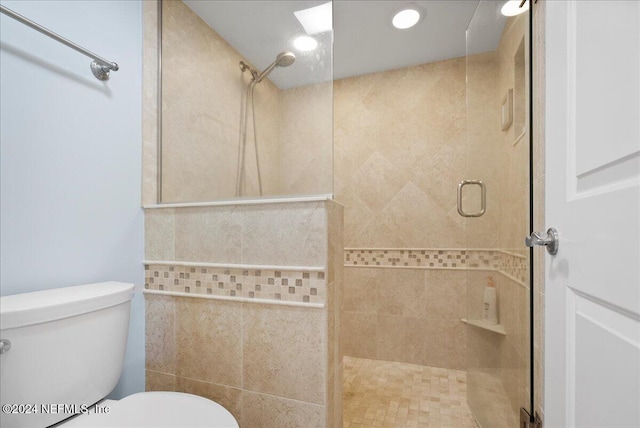 bathroom with toilet, an enclosed shower, and tile walls