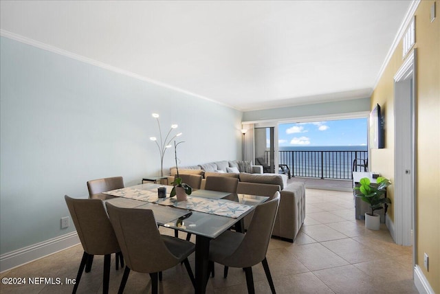 dining area with ornamental molding and a water view