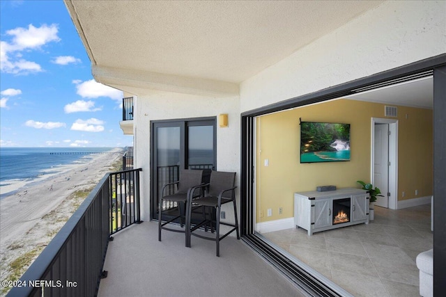 balcony with a water view and a view of the beach