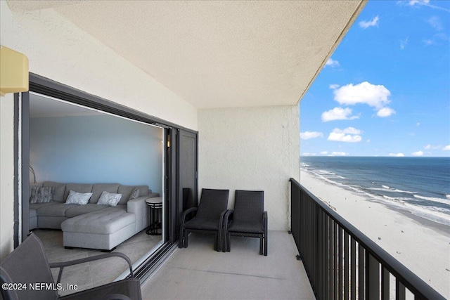 balcony featuring a view of the beach and a water view