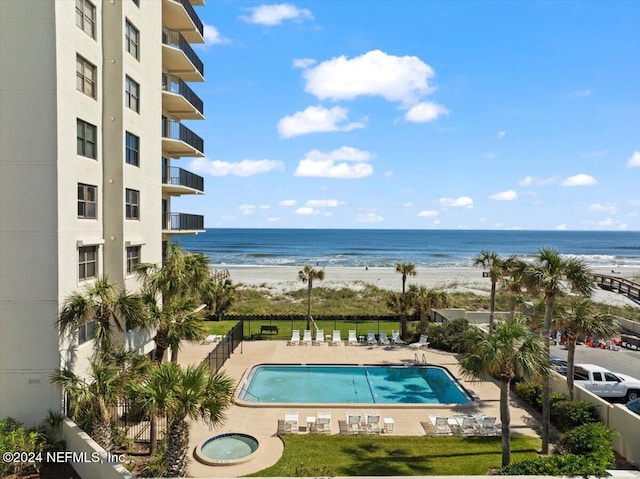 view of pool with a water view and a view of the beach