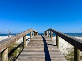 dock area with a water view and a view of the beach