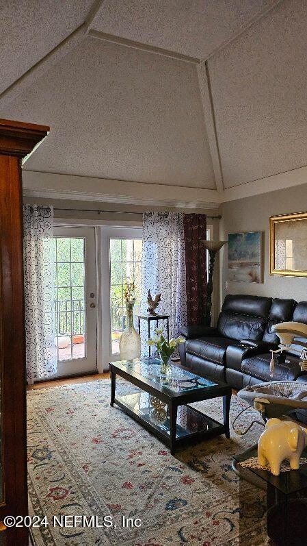 living room with a textured ceiling and vaulted ceiling