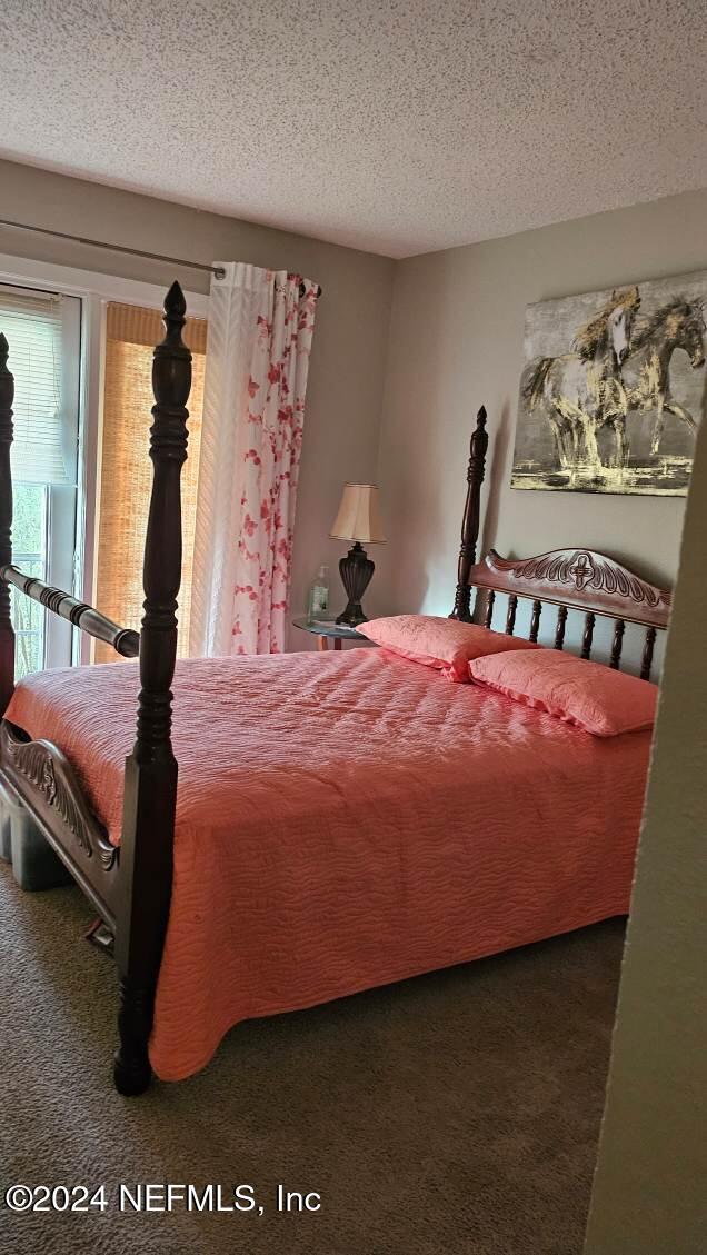 carpeted bedroom featuring a textured ceiling