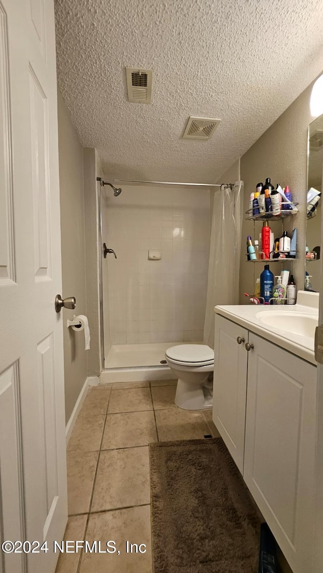 bathroom featuring vanity, curtained shower, toilet, and tile patterned floors