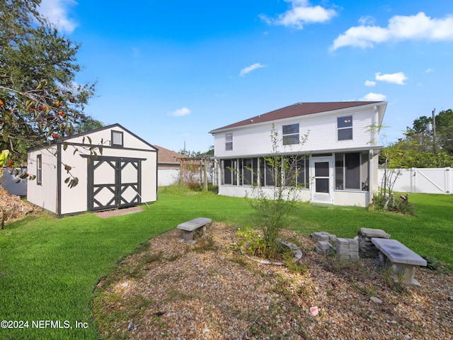 rear view of property with a storage unit, a lawn, and a sunroom