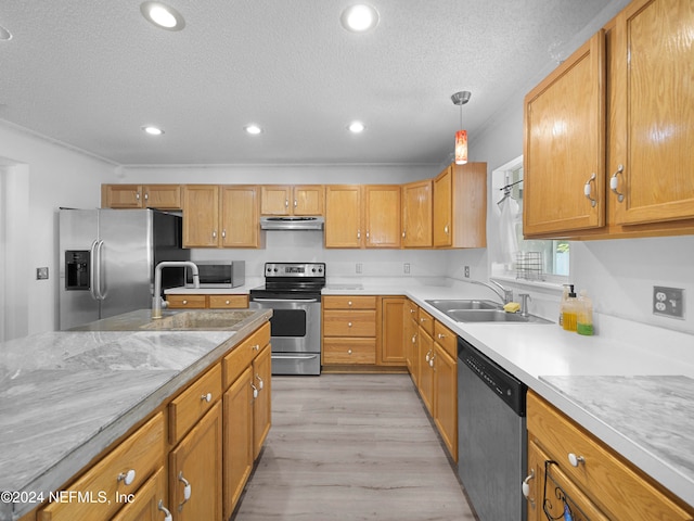 kitchen with appliances with stainless steel finishes, sink, a textured ceiling, decorative light fixtures, and light hardwood / wood-style flooring