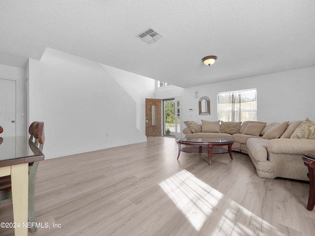 living room with a textured ceiling and light wood-type flooring