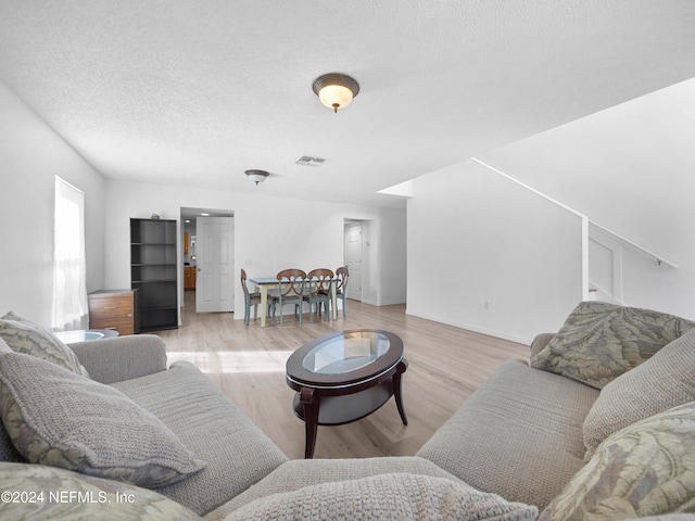 living room featuring a textured ceiling and light hardwood / wood-style flooring