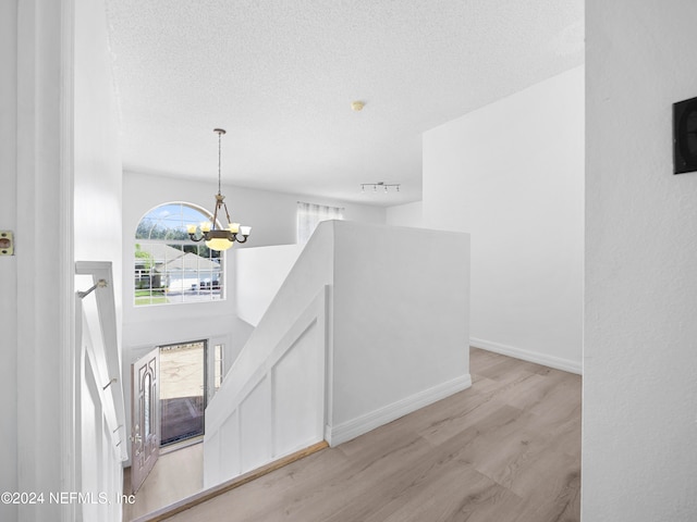 corridor featuring light hardwood / wood-style floors and a notable chandelier