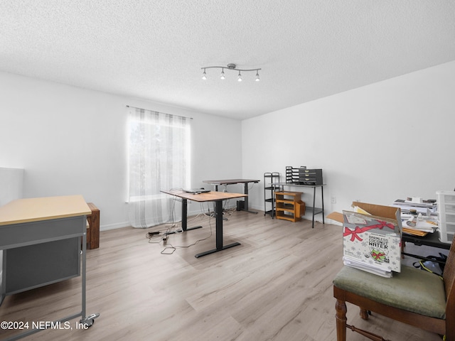 interior space with a textured ceiling and light wood-type flooring