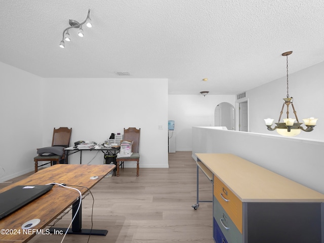 office area featuring a textured ceiling, a chandelier, and light wood-type flooring