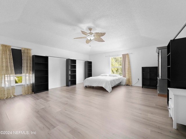 unfurnished bedroom featuring light hardwood / wood-style flooring, a textured ceiling, and ceiling fan