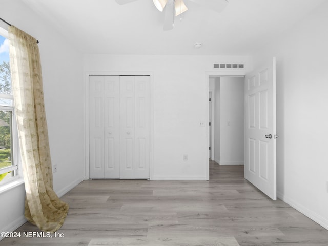 unfurnished bedroom featuring light hardwood / wood-style flooring, a closet, and ceiling fan