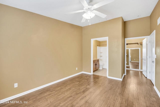 unfurnished bedroom featuring light hardwood / wood-style flooring, ceiling fan, and ensuite bath