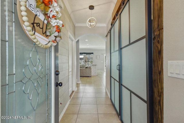 hallway featuring light tile patterned floors and crown molding