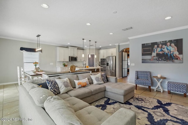 tiled living room with ornamental molding and sink