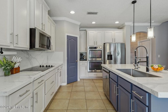 kitchen with stainless steel appliances, blue cabinetry, pendant lighting, sink, and white cabinets