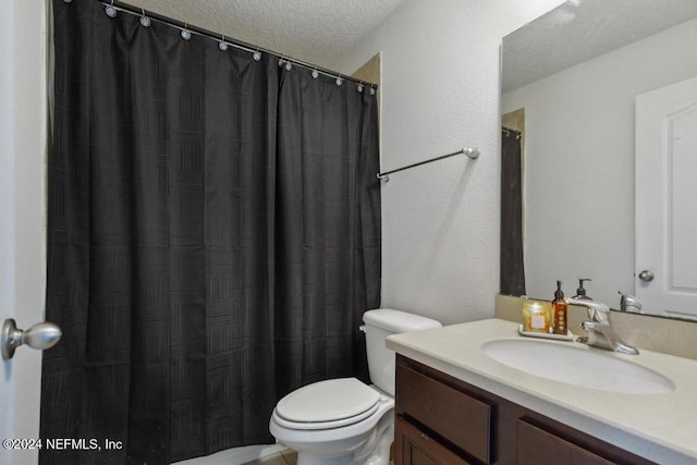 bathroom with vanity, a textured ceiling, and toilet