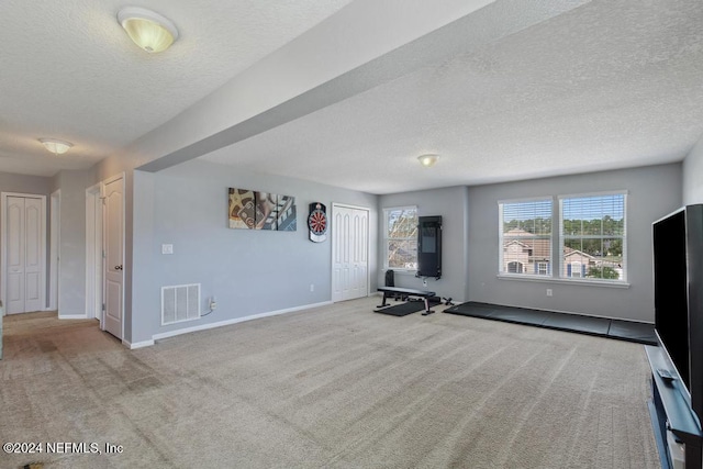 unfurnished living room featuring a textured ceiling and light carpet