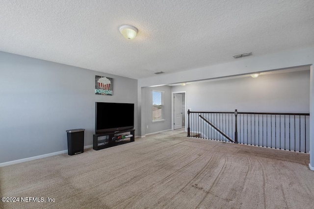 unfurnished living room featuring a textured ceiling and light carpet