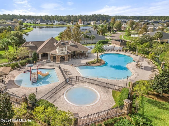 view of swimming pool featuring a hot tub, a patio area, and a water view