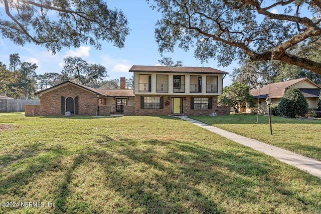 view of front of property with a front lawn and a balcony