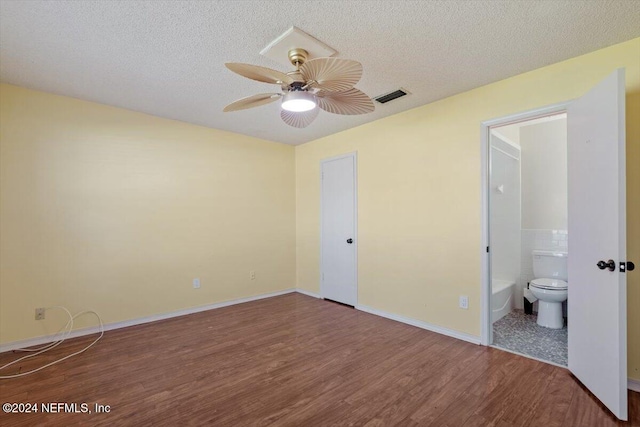 unfurnished bedroom featuring connected bathroom, wood-type flooring, ceiling fan, and a textured ceiling