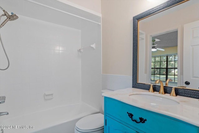 full bathroom featuring ceiling fan, vanity, toilet, and tiled shower / bath