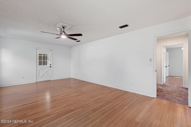 empty room with light wood-type flooring, a textured ceiling, and ceiling fan