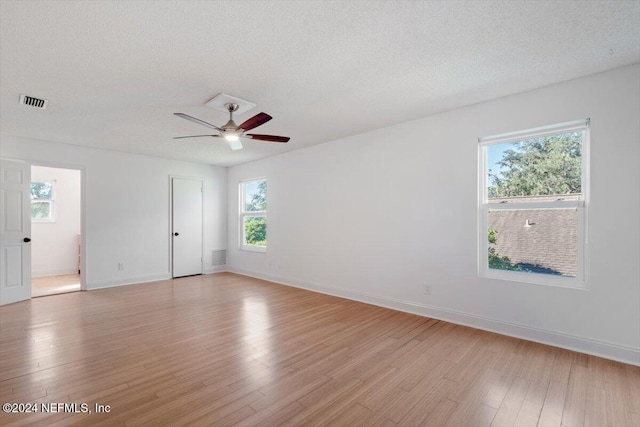 spare room featuring ceiling fan, a textured ceiling, and light wood-type flooring