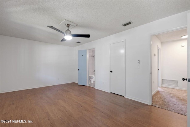 unfurnished bedroom with ensuite bathroom, ceiling fan, a textured ceiling, hardwood / wood-style floors, and a closet