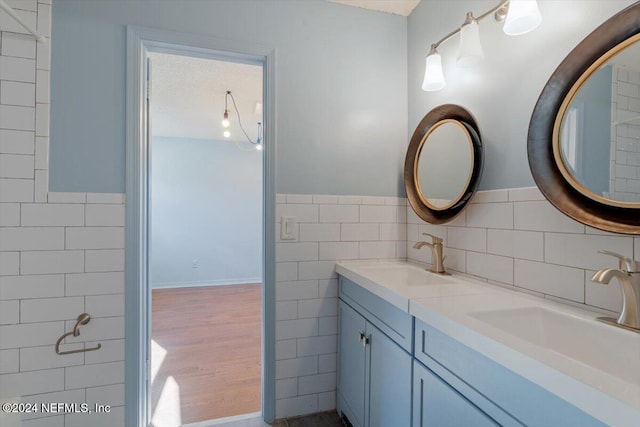 bathroom with tile walls, wood-type flooring, and vanity