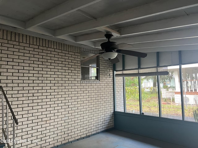 unfurnished sunroom featuring ceiling fan