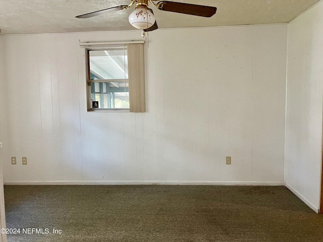 spare room with dark carpet, a textured ceiling, and ceiling fan