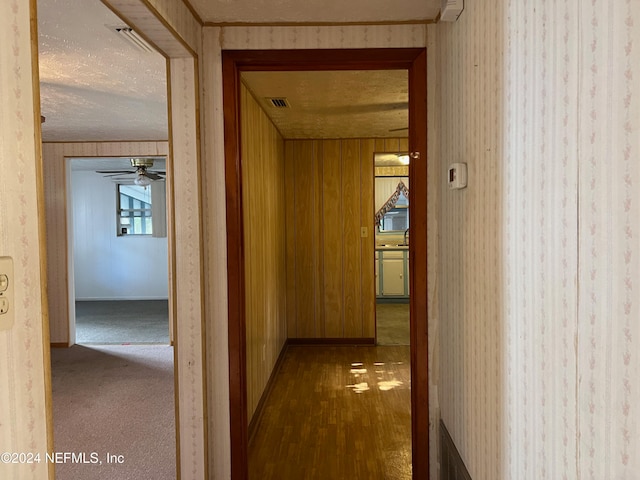 corridor featuring hardwood / wood-style flooring, sink, and wood walls