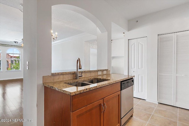 kitchen with dishwasher, ornamental molding, sink, light stone countertops, and a textured ceiling