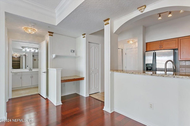 kitchen featuring light stone countertops, a textured ceiling, dark hardwood / wood-style flooring, and stainless steel refrigerator with ice dispenser