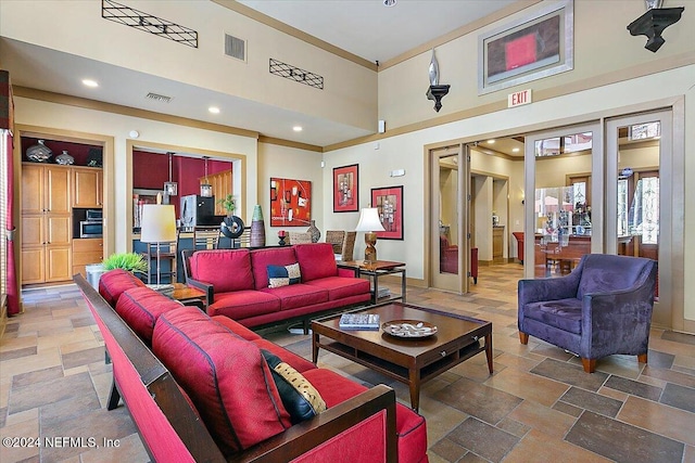 living room featuring a high ceiling and crown molding