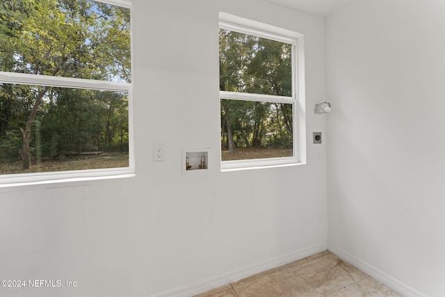 laundry area featuring washer hookup, a healthy amount of sunlight, light tile patterned floors, and electric dryer hookup