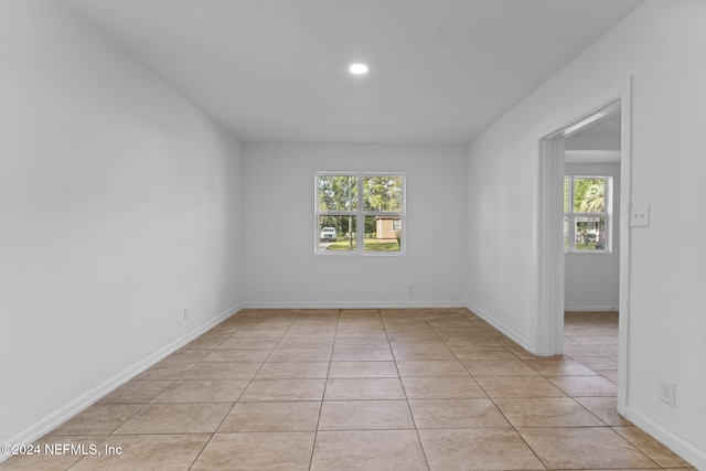 empty room featuring light tile patterned floors and plenty of natural light