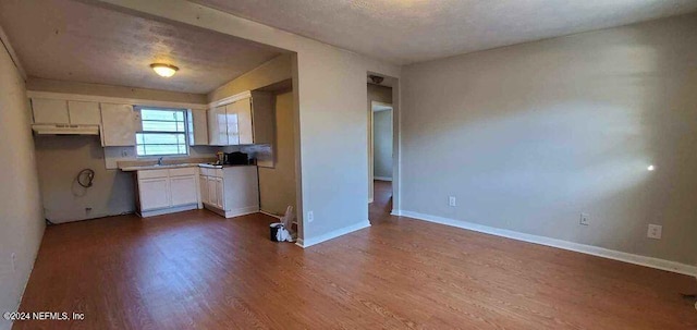 1657 Union St W, Jacksonville, FL 32209 - kitchen featuring white cabinetry, a textured ceiling, and hardwood / wood-style floors