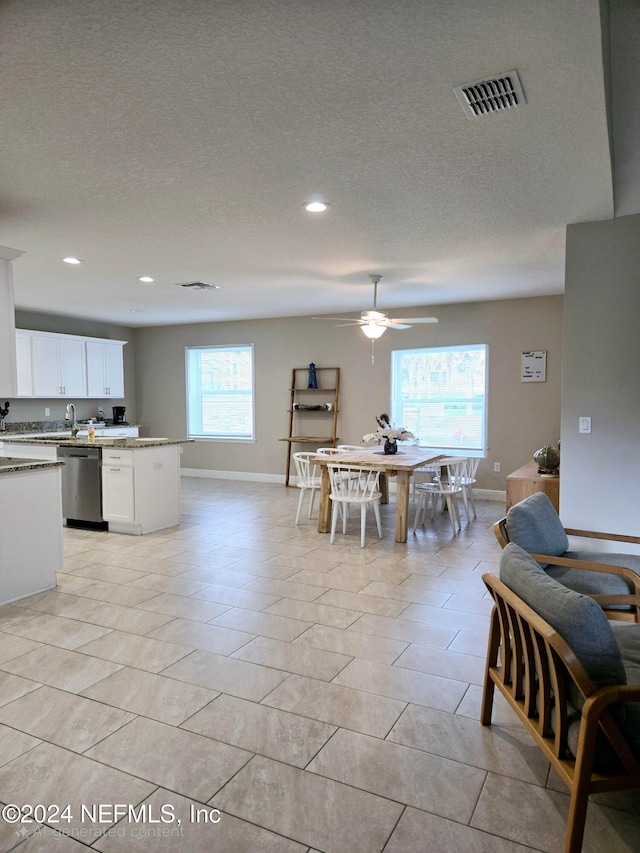 tiled dining room featuring sink, a textured ceiling, and ceiling fan