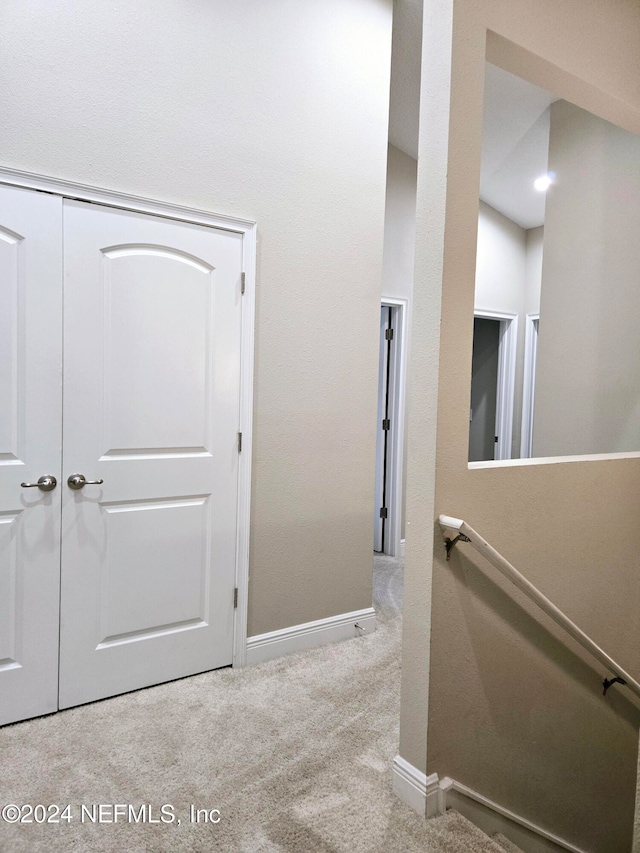 hallway featuring light colored carpet