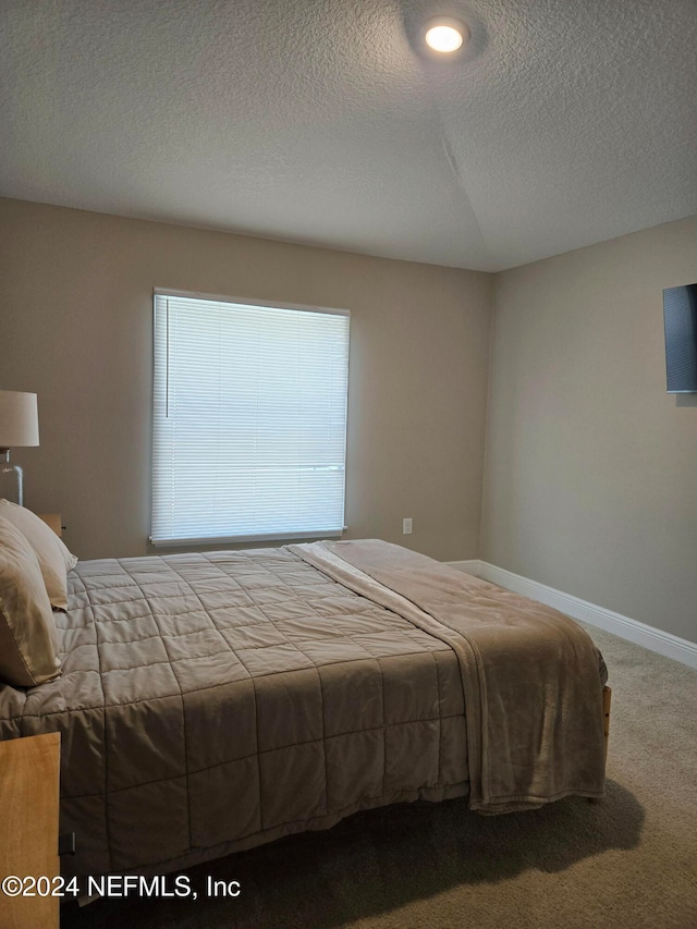 bedroom featuring a textured ceiling and carpet