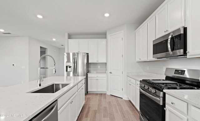 kitchen with white cabinets, appliances with stainless steel finishes, and sink