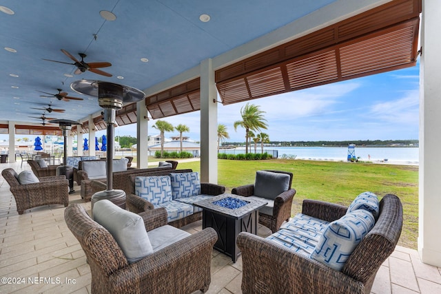 view of patio / terrace featuring a water view and an outdoor living space with a fire pit