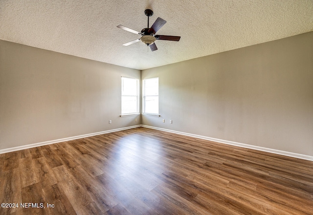 spare room featuring dark wood-type flooring, a textured ceiling, and ceiling fan