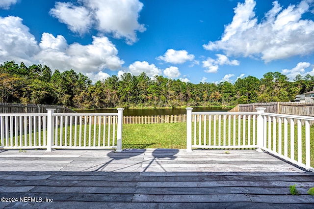 wooden terrace with a lawn and a water view